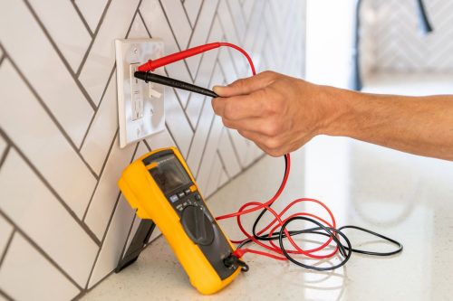 Commercial electrician services professional testing electrical equipment for safety